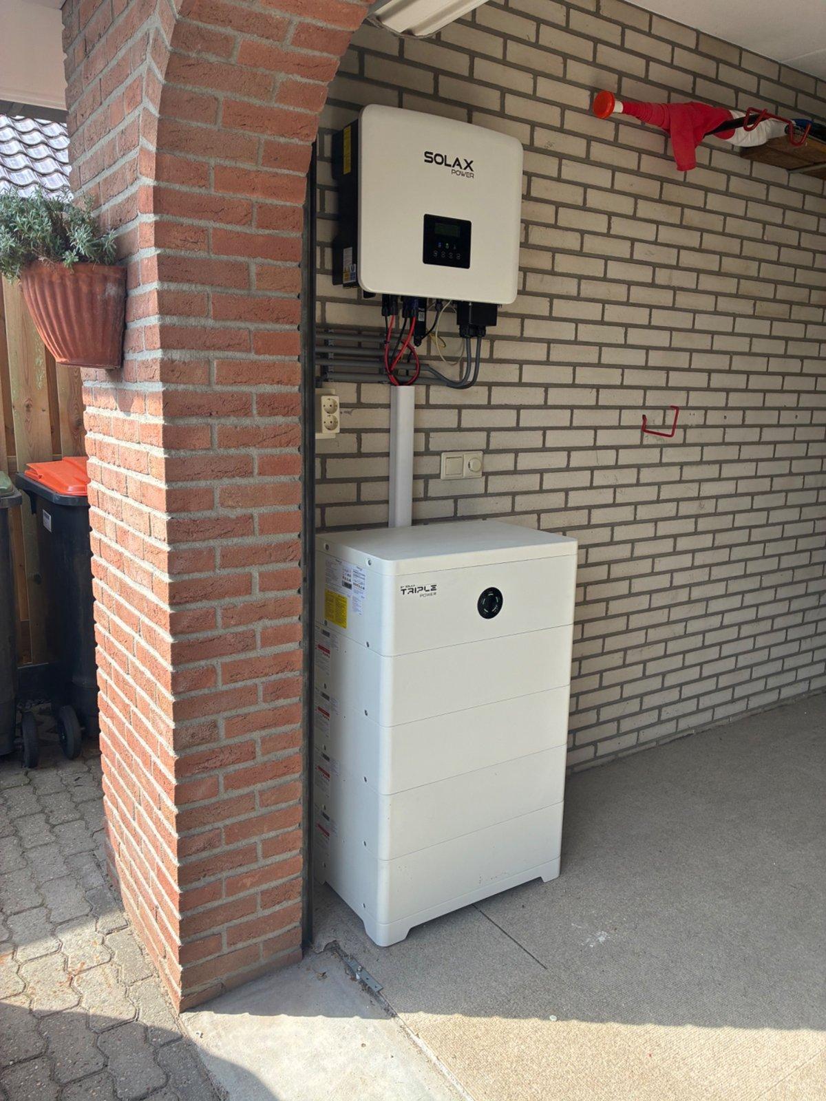 Hybride omvormer en thuisbatterij onder de carport van de woning in Vroomshoop