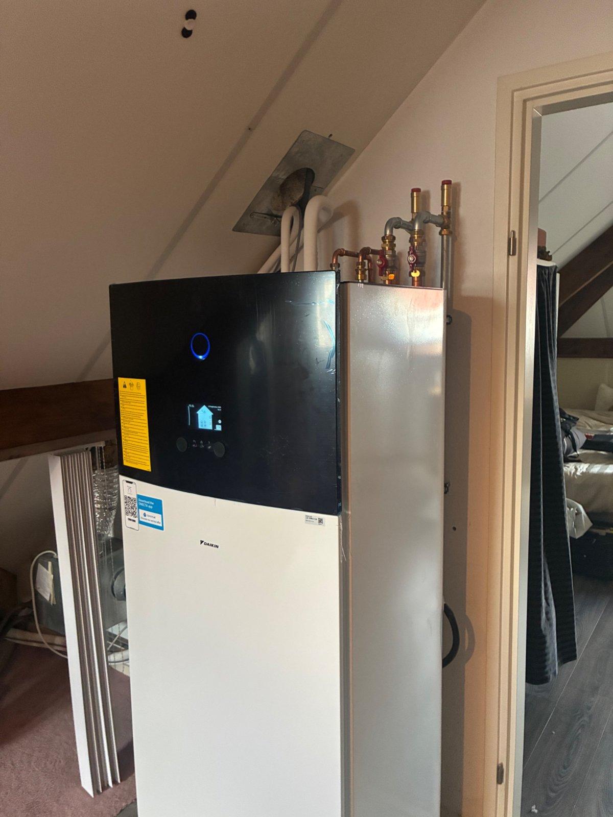 Binnenunit van de warmtepomp met warmwatertank op zolder