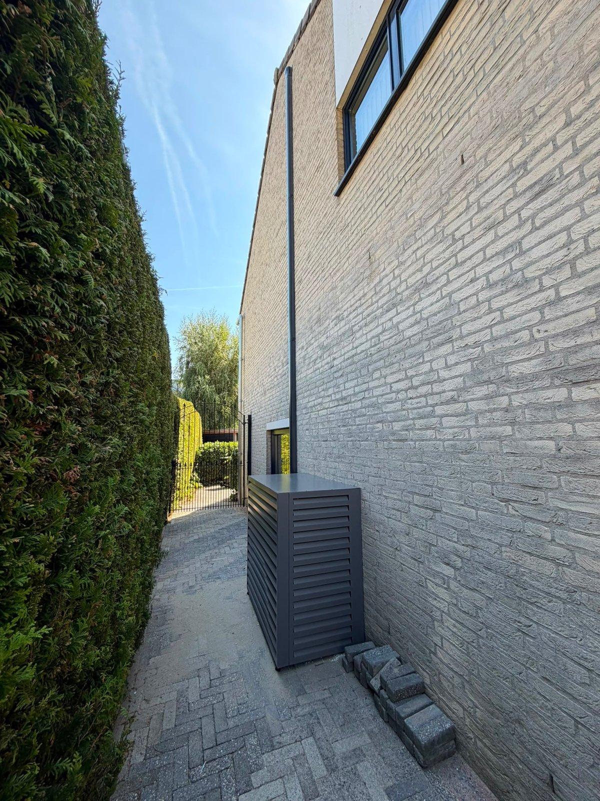 Omkasting van de buitenunit langs de zijgevel van de woning in Alblasserdam